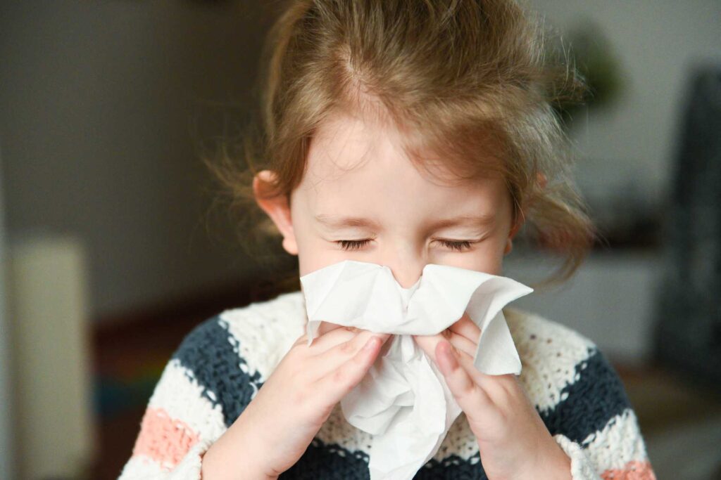Bambina che si soffia il naso per raffreddore
