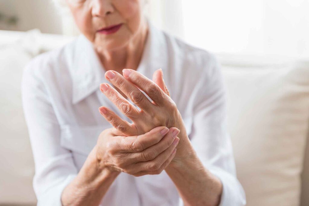 Donna anziana si tocca il polso dolorante a causa dell'artrite