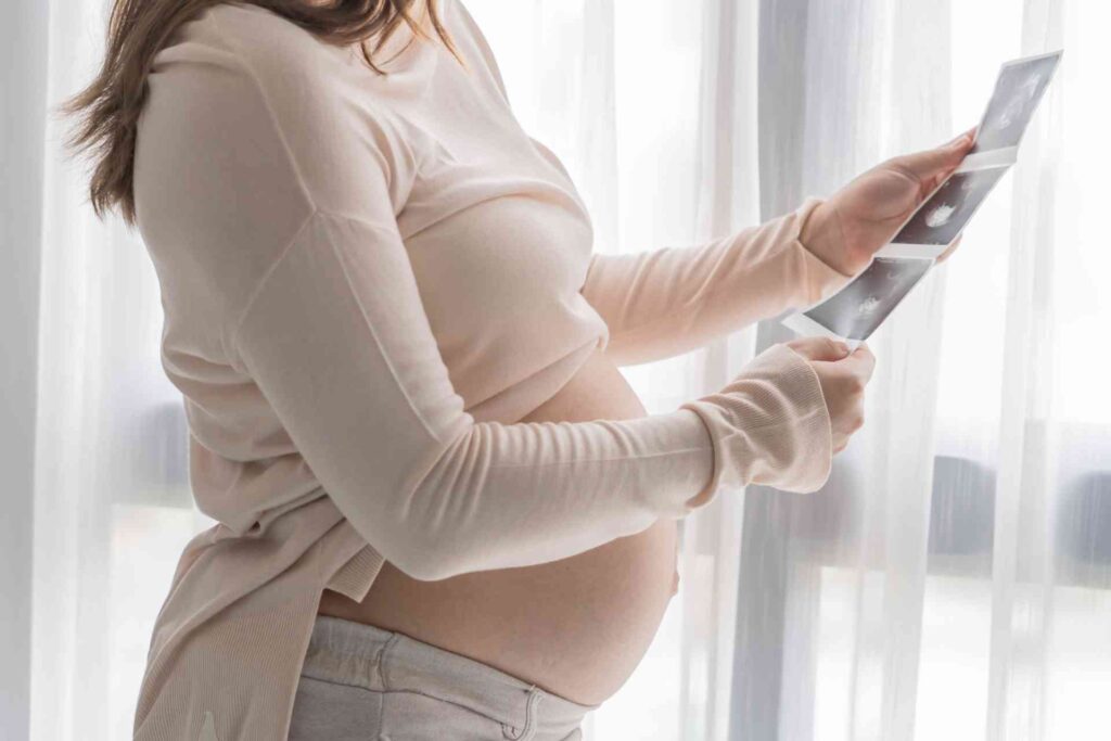 Donna incinta guarda il risultato dell'esame fatto in gravidanza