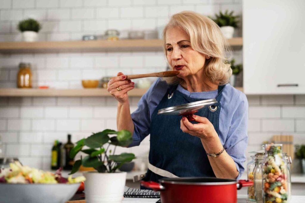Donna over 60 prepara il pranzo seguendo la dieta per diverticoli intestinali
