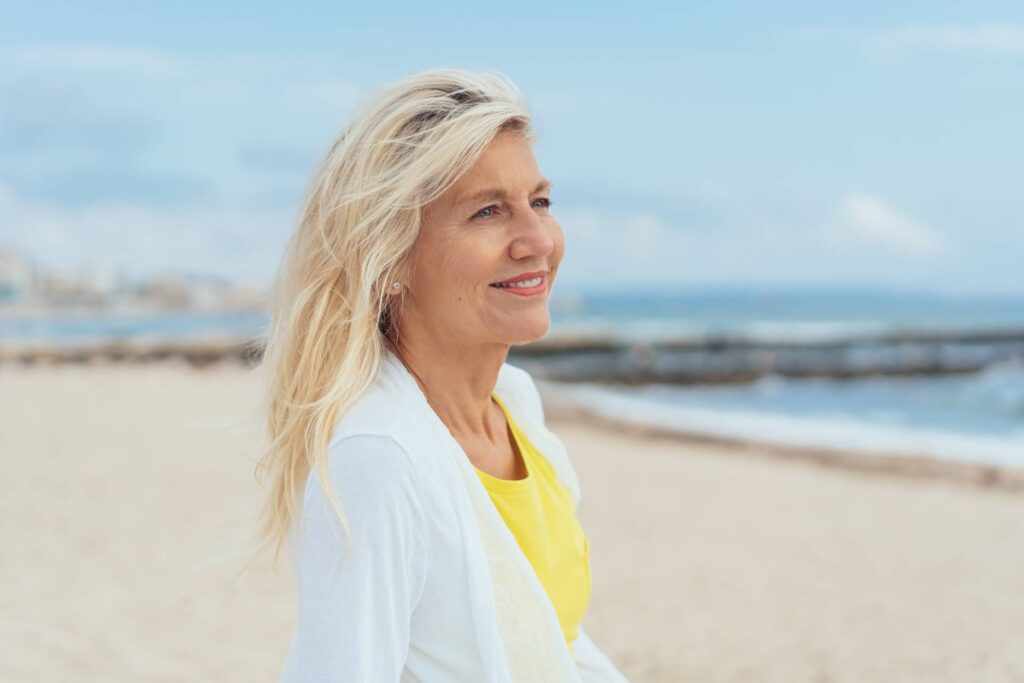 Donna in menopausa sorride guardando il mare
