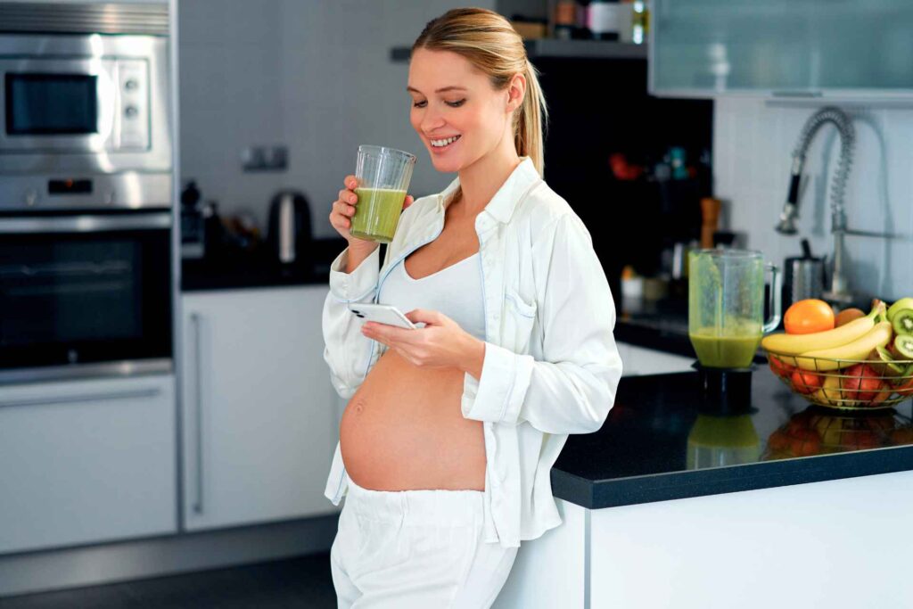 Donna in gravidanza che beve un succo