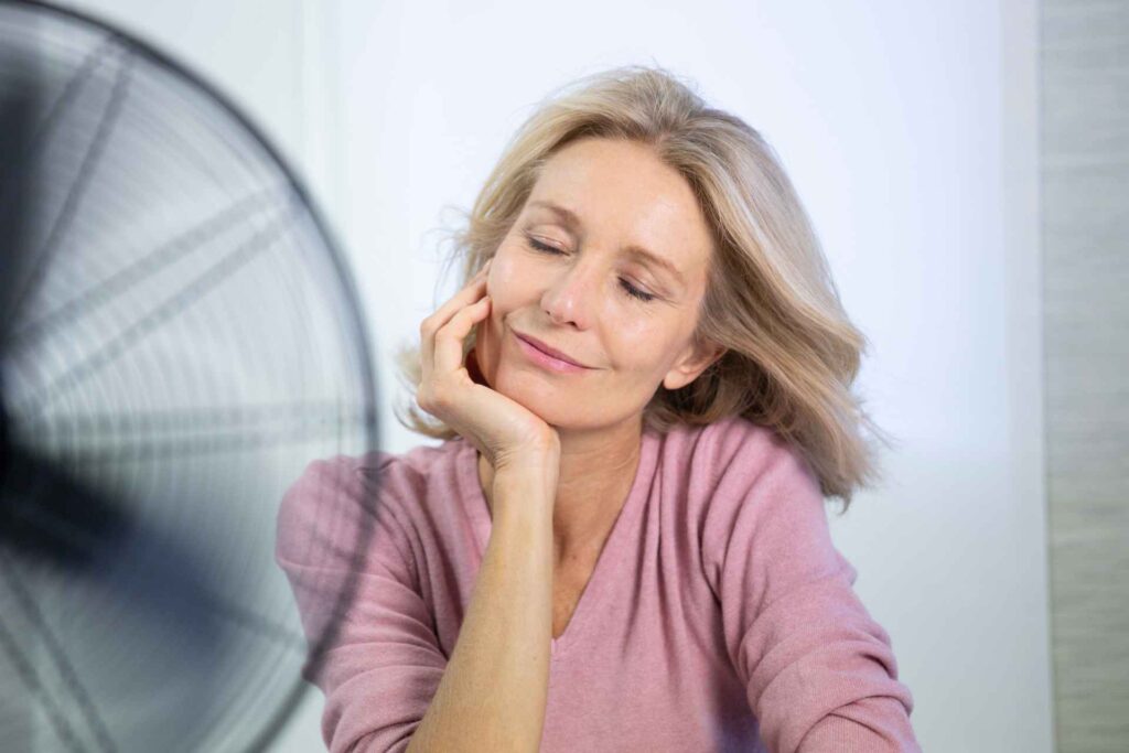 donna davanti al ventilatore per le vampate in menopausa