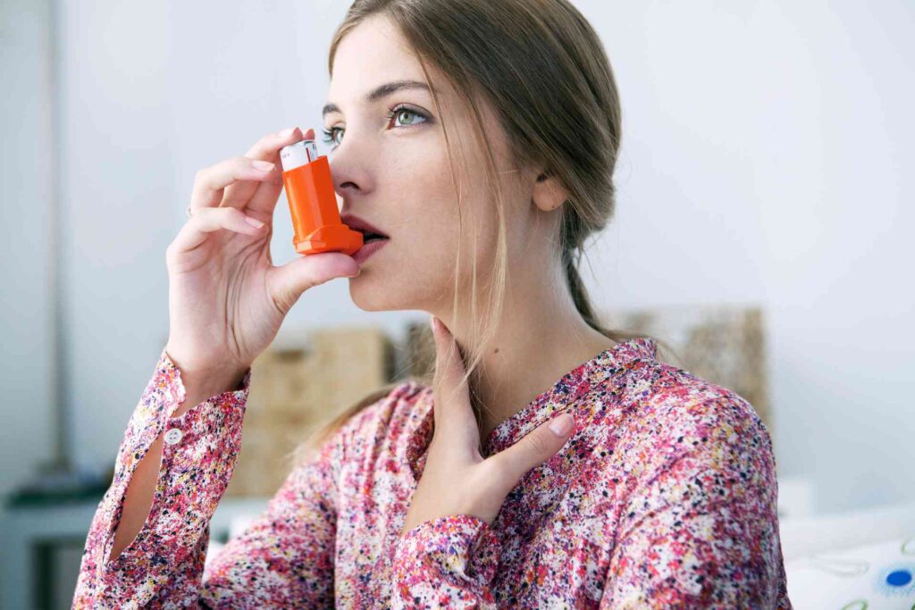 Donna con asma usa l'inalatore