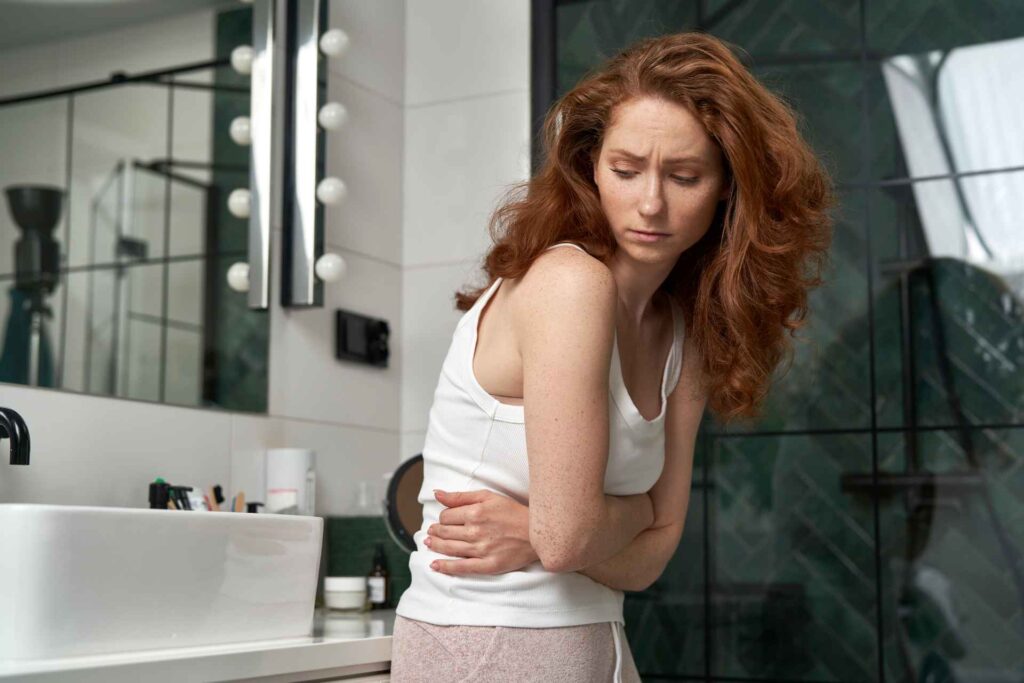 donna in bagno soffre di crampi mestruali e di diarrea