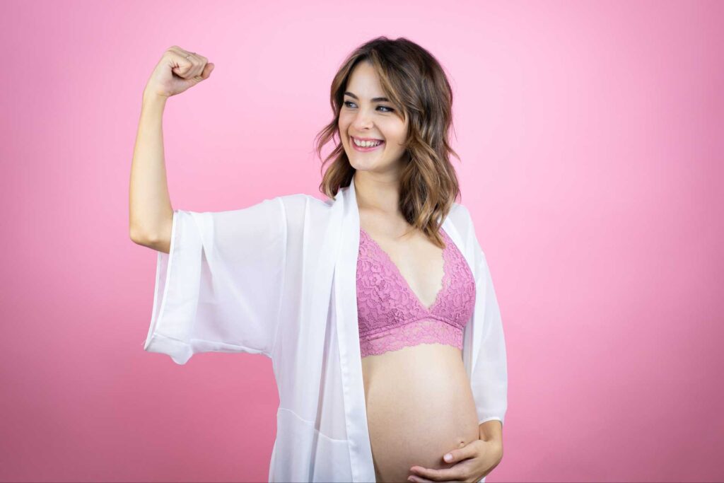 donna in gravidanza che fa segno di forza riferendosi alle difese immunitarie