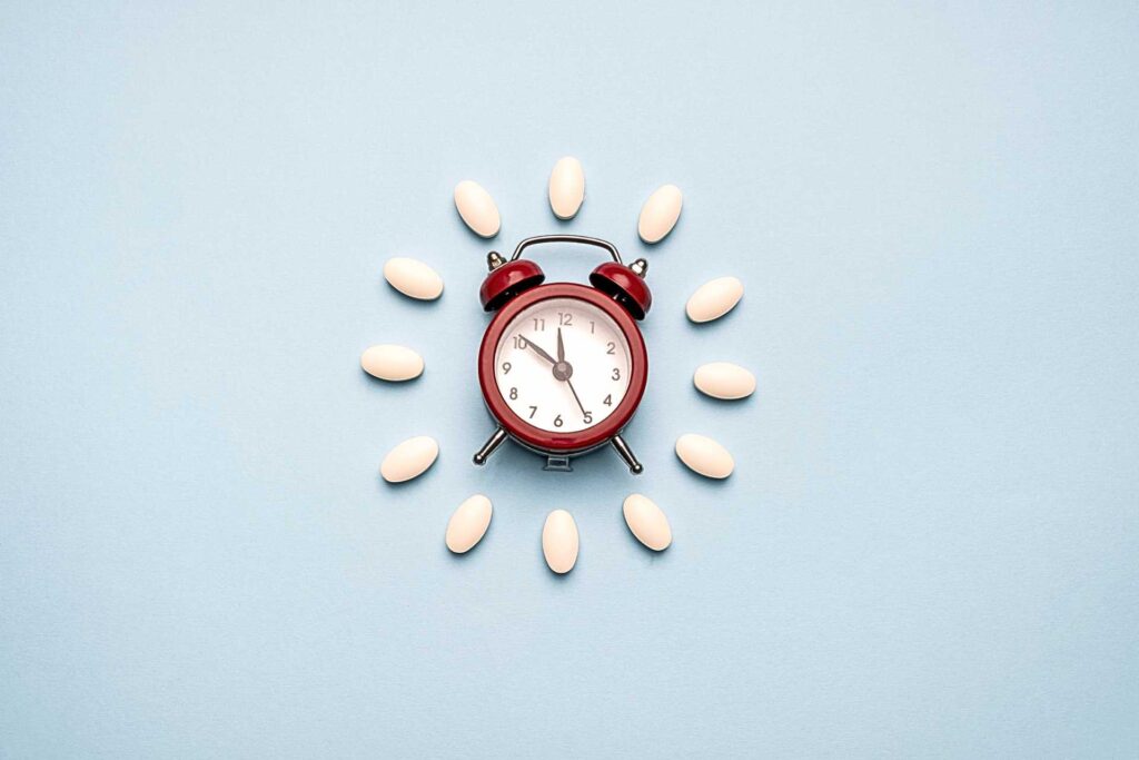 un orologio con pillole di probiotici attorno per indicare l'ora in cui assumerli