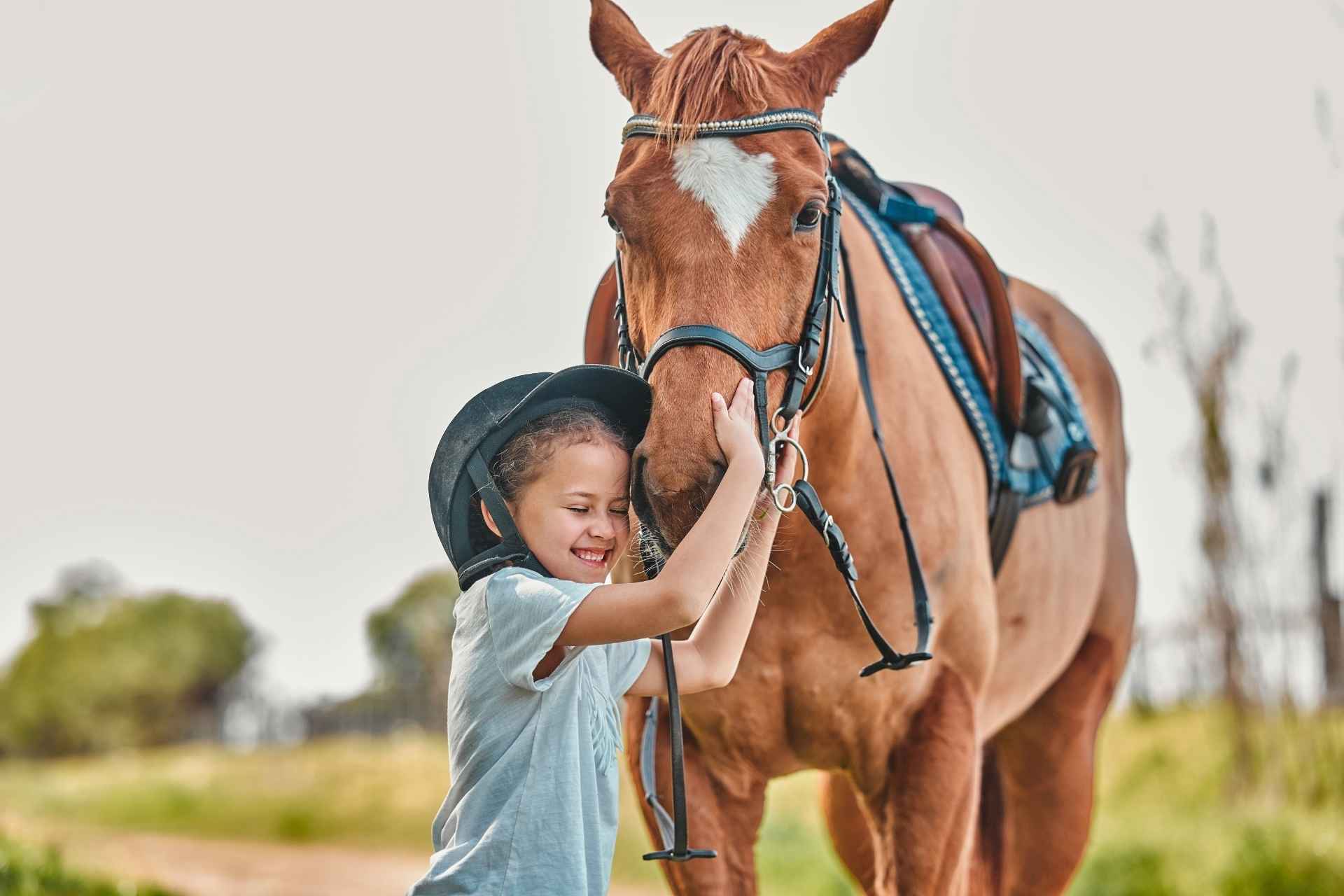 bambino felice abbraccia un cavallo