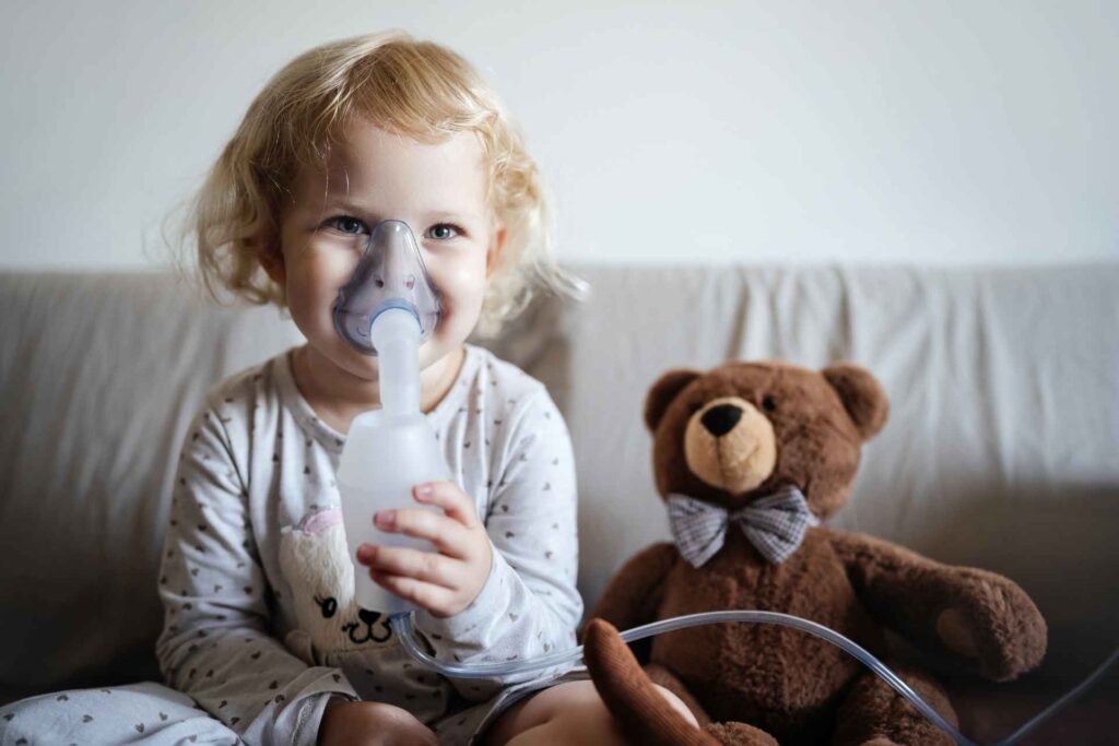 Bambino fa l'aerosol accanto al suo peluche