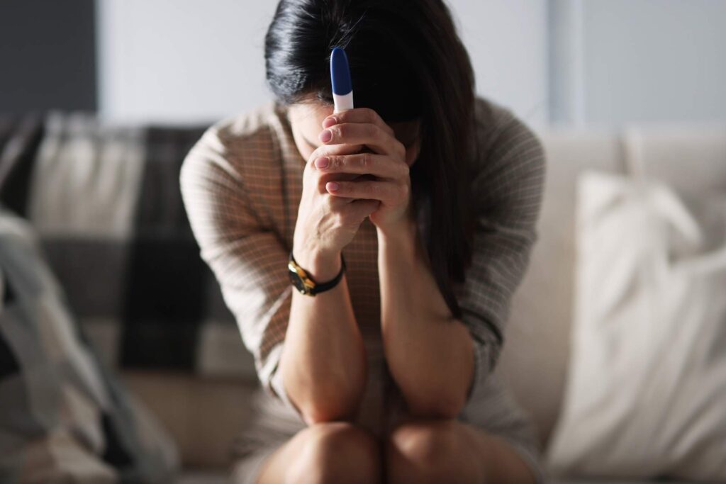 donna triste dopo aver fatto test di gravidanza